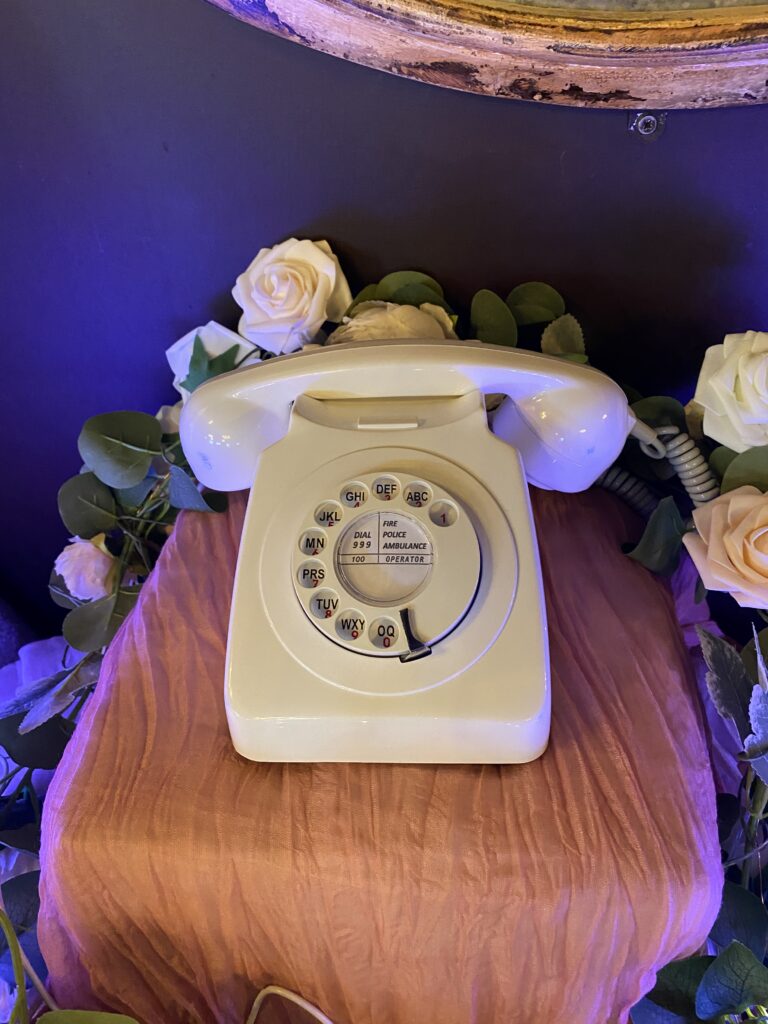 Brilliant white retro telephone audio guestbook on pink drapes