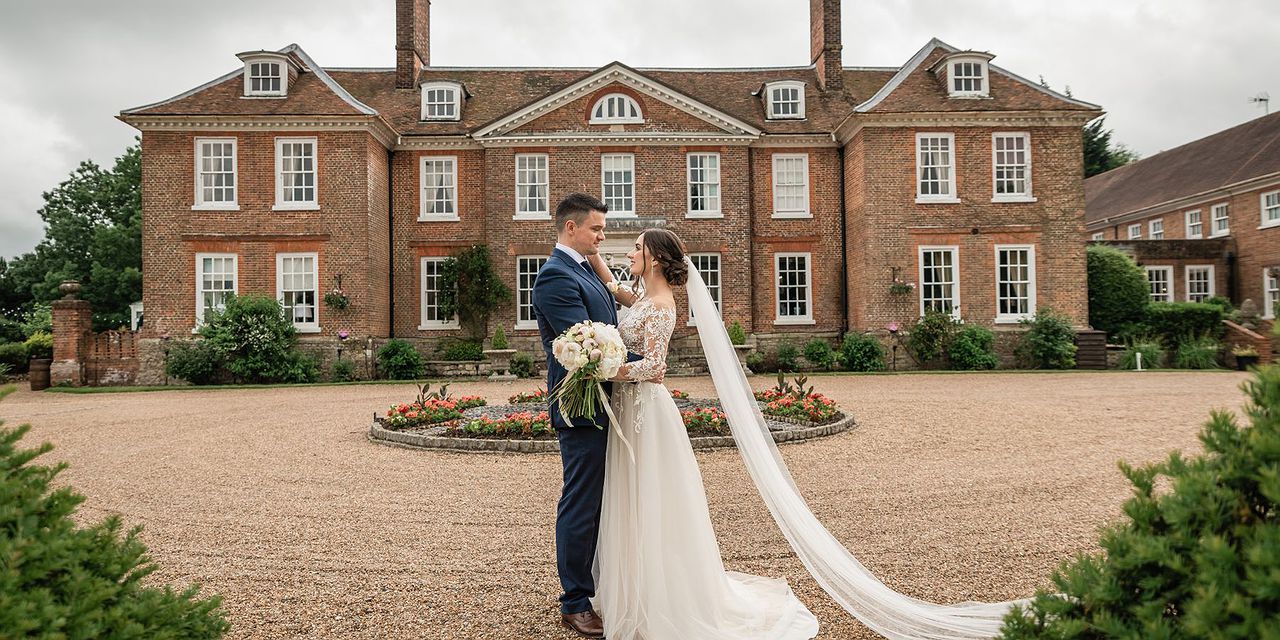 Bride and Groom standing at the front of Chilston Park wedding venue in Maidstone